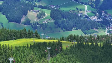 Por-Encima-De-Las-Hermosas-Copas-De-Los-árboles,-Los-Telesillas-Llevan-A-La-Gente-De-Vacaciones-En-Austria