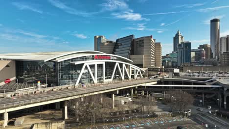 Aerial-approaching-shot-of-State-Farm-Arena-and-skyline-of-Atlanta-City-in-Background,-USA