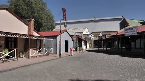 Pan-across-Old-Town-street-by-Big-Hole-Mine-Museum-in-Kimberley,-RSA