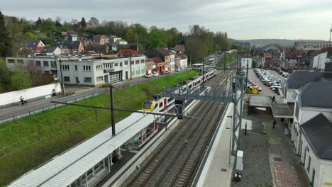 SNCB-Train-Leaving-the-Railway-Station-in-Wavre,-Aerial-Follow