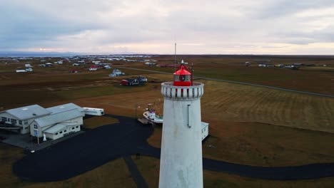 Aerial-orbit-of-the-top-of-a-tall-lighthouse-on-a-calm-morning-near-the-ocean