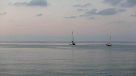 Two-small-yachts-moored-offshore-at-dusk
