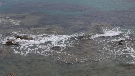 Kleine-Wellen-Brechen-Sanft-über-Flache-Felsen-An-Der-Küste