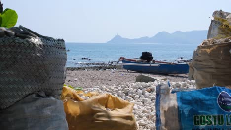 Vista-Panorámica-Del-Paisaje-De-La-Playa,-El-Barco-Pesquero-Local-Y-La-Estatua-De-Cristo-Rei-En-La-Distancia-En-Dili,-Timor-leste,-Sudeste-Asiático