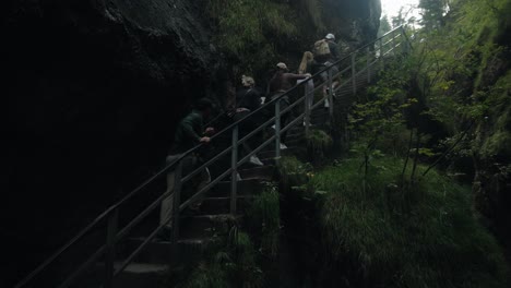 Push-in-tilt-up-follows-young-group-of-attractive-men-and-woman-hiking-in-Almbachklamm-Germany