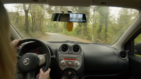 Frau-Fährt-Auto,-Herbstliche,-Von-Bäumen-Gesäumte-Schmale-Landstraße-Mit-Blick-Auf-Den-Rücksitz