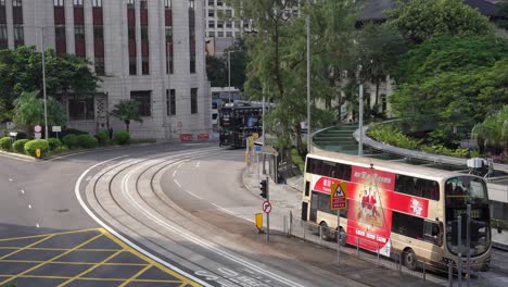 Aerial-of-double-decker-trams-and-buses-crossing-on-the-busy-streets-of-Hongkong,-China