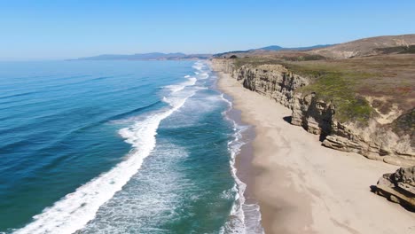 Breathtaking-aerial-drone-shot-of-Pescadero-Coast-in-San-Mateo,-California,-with-a-stunning-shoreline,-mountains-on-the-right-side-capturing-the-scenic-beauty-as-it-flies-straight-ahead