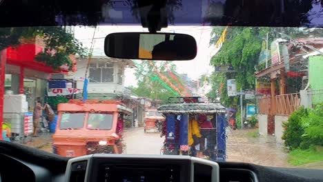 Vista-De-Coloridos-Taxis-Triciclo-Filipinos-A-Través-Del-Parabrisas-Del-Taxi-En-Las-Calles-Húmedas-De-Coron-En-Palawan,-Filipinas,-Sudeste-Asiático