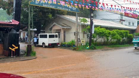 Colorful-Filipino-tricycle-taxis-driving-through-floods-on-wet-streets-during-monsoon-season-in-Coron,-Palawan,-Philippines