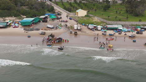 Los-Pescadores-Comercializan-El-Pescado-Cosechado-A-Los-Comerciantes-Locales-En-La-Orilla-Del-Mar,-Orbital-Aéreo.