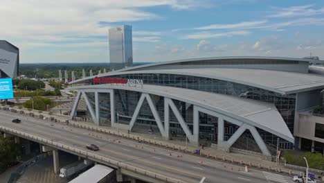 Aerial-drone-shot-of-driving-vehicles-in-front-of-State-Farm-Arena-and-Signia-Hilton-in-Atlanta-City