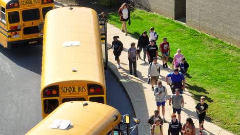 Schüler-Steigen-Nach-Der-Entlassung-An-Einer-Amerikanischen-Schule-In-Gelbe-Schulbusse