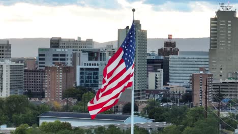 American-flag-waving-in-front-of-city-skyline-in-USA