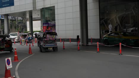 Tuk-tuk-bikes,-known-as-Sam-Lor-,-ride-off-the-passenger's-drop-off-point-at-Terminal-21,-Bangkok,-Thailand