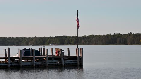 View-of-dock-on-calm-lake-with-American-Flag