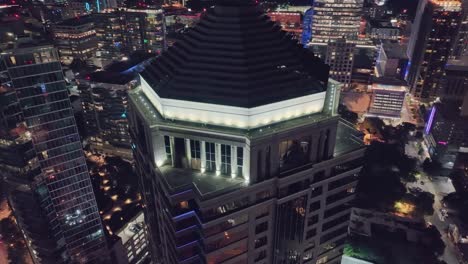 Aerial-orbiting-shot-showing-luxury-rooftop-of-Kilpatrick-Townsend-and-Stockton-LLP-in-downtown-of-Atlanta-City-at-night,-USA-