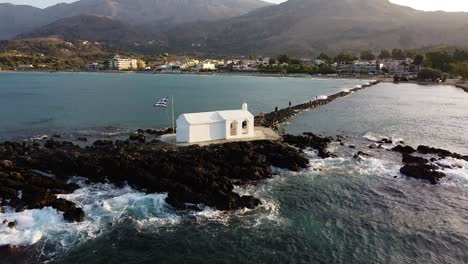 White-chapel-with-Greece-flag-in-Georgiopoli,-Crete,-aerial-view