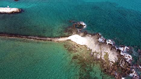 Iconic-small-chapel-on-rocky-island,-aerial-view