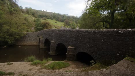 Side-wide-shot-of-stone-bridge-at-Wetton-mill-looking-east