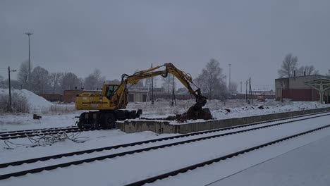 Eisenbahnbagger-Gräbt-Und-Bewegt-Schmutz-Entlang-Der-Eisenbahnstrecke-Im-Schneesturm