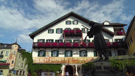 Mozartstatue-Mit-Schönen-Häusern-Im-Hintergrund-Im-Kurort-Saint-Gilgen