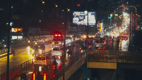 Captivating-rain-shower-envelops-the-night-traffic-on-Saigon-bridge,-as-cars-and-motorbikes-navigate-through-the-mesmerizing-downpour