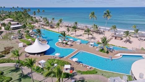 Tropical-swimming-pool-area-with-ocean-view-in-the-Dominican-Republic,-aerial