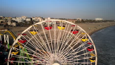 Eine-Außergewöhnlich-Nahe-Drohnenaufnahme-Des-Riesenrads-Mit-Strandbesuchern,-Die-Nicht-Identifiziert-Werden-Können