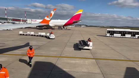 Passenger-POV-Baggage-unloading-or-loading-cars-waiting-to-approach-airplane-side-at-Montevideo-Carrasco-International-airport