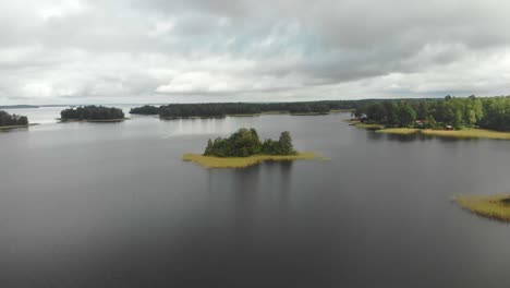 Flying-over-ojarp-lake-near-Piksborg-during-cloudy-day,-aerial