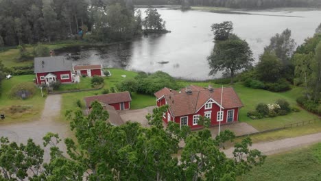 Famous-Piksborg-red-houses-in-middle-of-nature-at-Sweden,-aerial