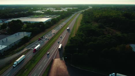 following-a-CDL-semi-truck-driver-entering-the-ramp-of-highway,-Sunset-aerial