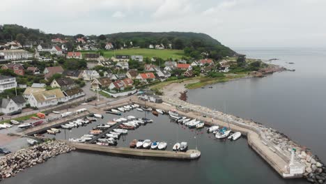 Flying-over-arild-harbour-with-small-sailing-boats-at-Sweden,-aerial