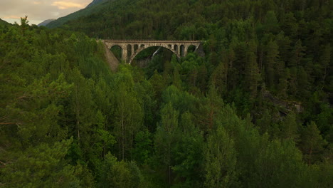 Aerial-tilt-up-of-historic-Kylling-bru,-stone-railway-bridge-in-Verma,-Norway
