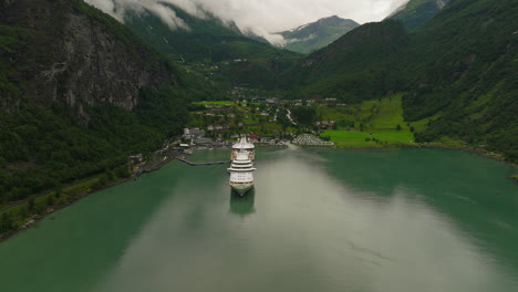 High-angle-aerial-over-scenic-Geiranger-fjord-with-docked-cruise-ship,-Norway