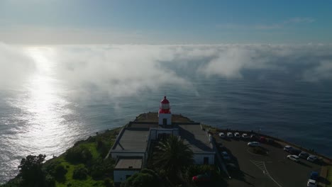 Ponta-Do-Pargo-Leuchtturm-Mit-Sonne-Und-Wolken,-Die-Sich-Im-Wasser-Spiegeln