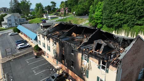 Luftaufnahme-Eines-Verbrannten-Wohnhauses-In-Den-USA-Mit-Verkohlten-Wänden,-Eingestürztem-Dach-Und-Autos-In-Der-Nähe