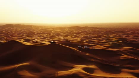 Aerial-view-of-4x4-off-road-land-vehicle-taking-tourists-on-desert-dune-bashing-safari-in-Dubai,-UAE