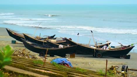 Wooden-fishing-boats-are-docked-on-the-shore-of-the-Bay-of-Bengal,-Kuakata,-Indian-ocean
