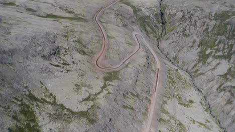 Herannahende-Drohnenaufnahme,-Die-Tagsüber-Eine-Gigantische-Vulkanlandschaft-Mit-Straße-Und-Fahrendem-Auto-Zeigt---Raudasandur-Straße,-Westfjorde,-Island