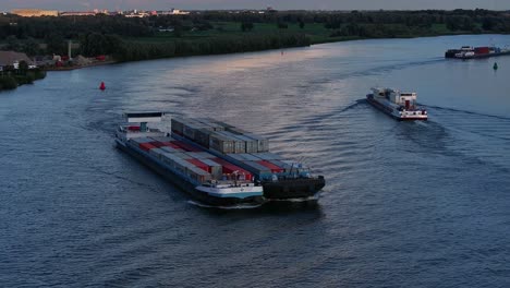 Drone-view-of-cargo-ships-with-colorful-containers-sailing-on-the-river-carrying-cargo