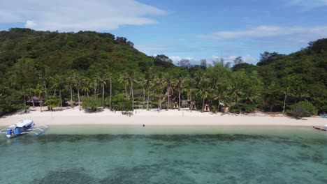 People-at-Coco-beach-resort-of-Bulalacao-island,-Philippines-with-tropical-vegetation-and-clear-water