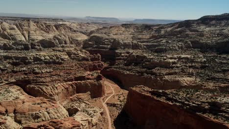Within-the-drone-footage-of-Capitol-Reef,-an-intriguing-double-pathway-emerges,-resembling-either-a-road-or-a-river,-creating-an-unusual-pattern-in-the-landscape