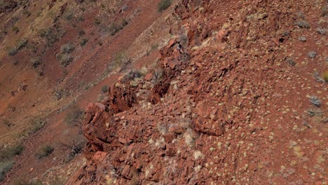 Man-walking-on-edge-of-rocky-mountain-during-hiking-adventure-in-Western-Australia-desert