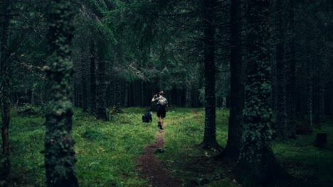 A-Man-Trekking-with-His-Dog-in-the-Woods-of-Indre-Fosen,-Norway---Static-Shot