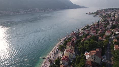 Coastline-Aerial:-Kotor's-serene-bay,-coastal-town-and-shimmering-waters