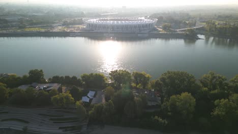 Drone-Flies-Above-Danube-River-to-Reveal-National-Atheltic-Center-in-Budapest,-Hungary