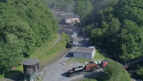 An-Aerial-View-of-an-Antique-Steam-Locomotive-Backing-Up-to-a-Water-Tower-to-Take-a-Drink-on-a-Sunny-Summer-Morning