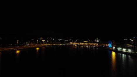 Las-Luces-Nocturnas-Se-Reflejan-En-El-Oscuro-Puerto-Marítimo-De-Helsinki,-Finlandia
